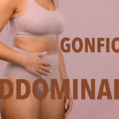 Donna con mano sull'addome, testo "Gonfiore Addominale". Attenzione ai cibi che gonfiano la pancia.
