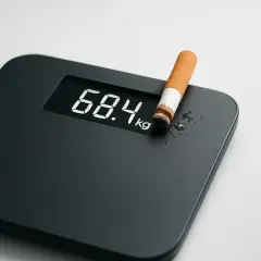 Bilancia digitale mostra 68.4 kg con una sigaretta. Forse qualcuno pensa che fumare fa dimagrire, ma è un mito pericoloso.