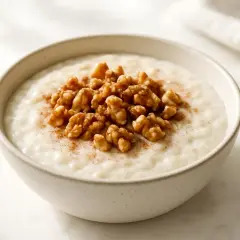 Una ciotola di porridge cremoso con noci e cannella, perfetta per una colazione a basso indice glicemico.