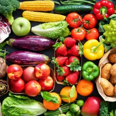 Varietà di verdure fresche e frutta, ideale per una tabella verdure per diabetici: broccoli, pomodori, peperoni, melanzane, fragole, patate, mele, arance, cavoli e altro.