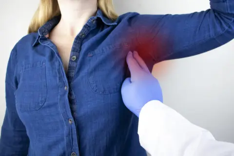 Medico esamina dolore sotto l'ascella sinistra, un sintomo che può essere associato a un infarto.