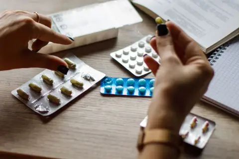 Mani con pillole e blister, cercando alternative cosa prendere al posto delle statine.