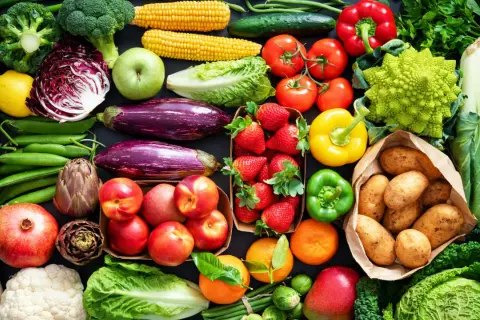 Varietà di verdure fresche e frutta, ideale per una tabella verdure per diabetici: broccoli, pomodori, peperoni, melanzane, fragole, patate, mele, arance, cavoli e altro.