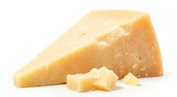 Un pezzo di Grana Padano, con scaglie sparse. Un alimento gustoso, ma attenzione al colesterolo.