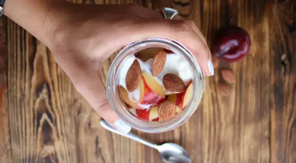 Un vasetto di yogurt con frutta e mandorle. Attenzione, le mandorle alzano la glicemia, ma sono deliziose!