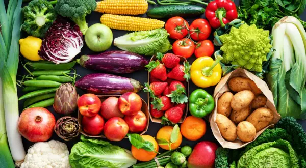 Varietà di verdure fresche e frutta, ideale per una tabella verdure per diabetici: broccoli, pomodori, peperoni, melanzane, fragole, patate, mele, arance, cavoli e altro.