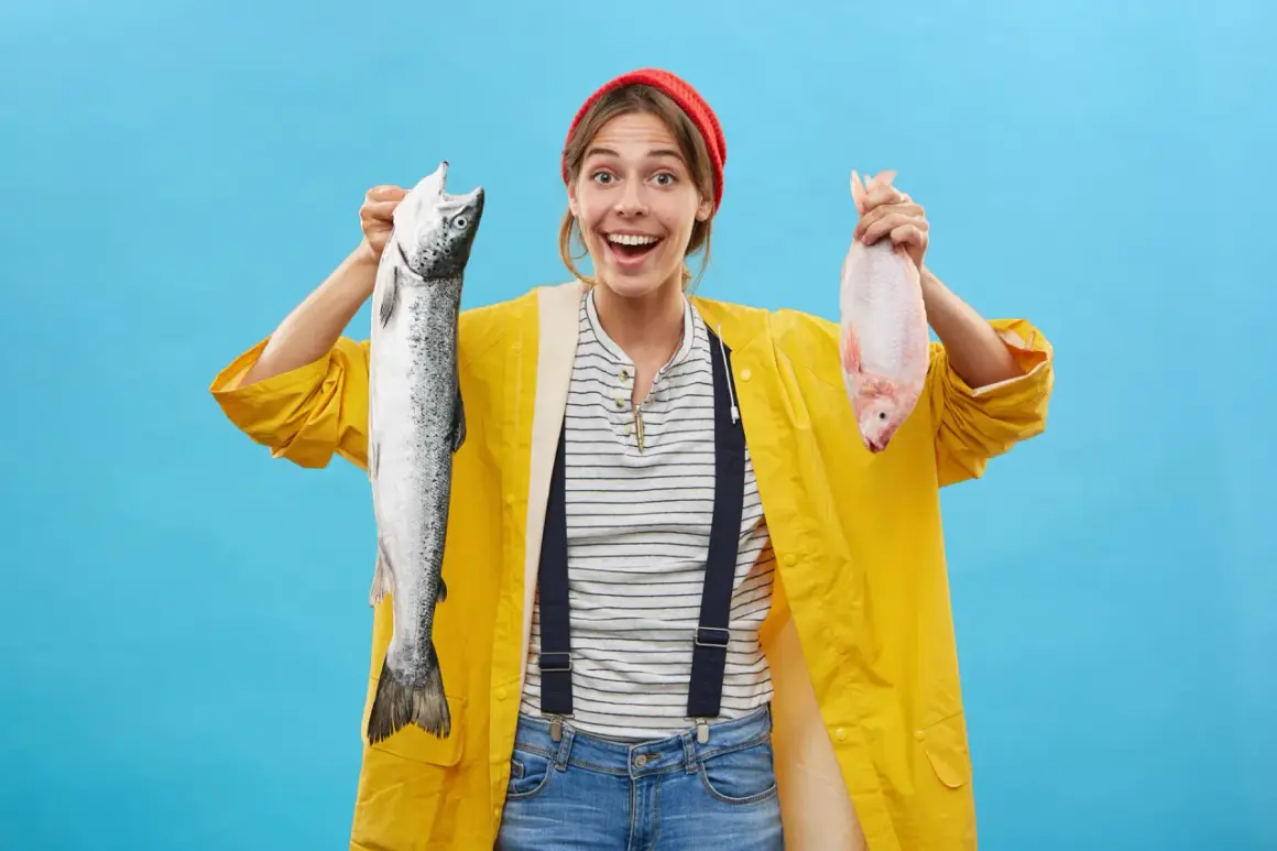 Donna sorridente con un salmone e un pesce rosso, un'idea su come sostituire il pesce nella dieta.