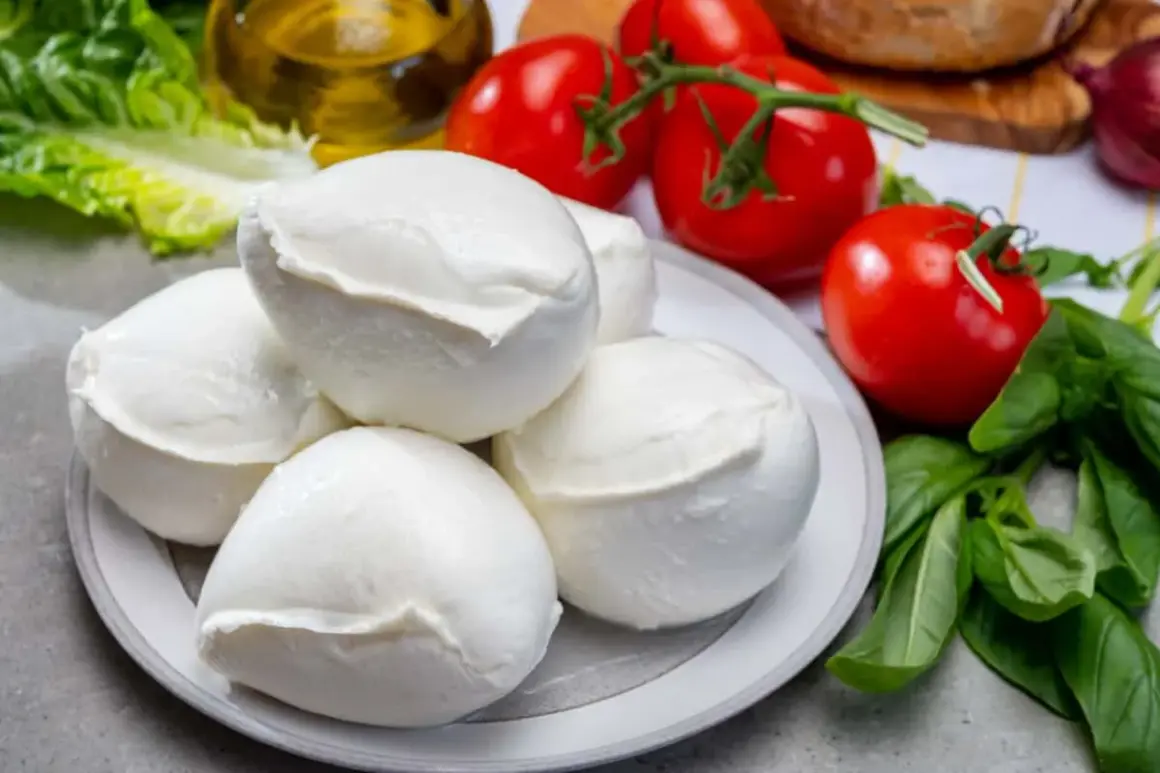 Mozzarella fresca su piatto, con pomodori, basilico e olio. Un piatto che, se mangiato in eccesso, potrebbe causare reflusso.