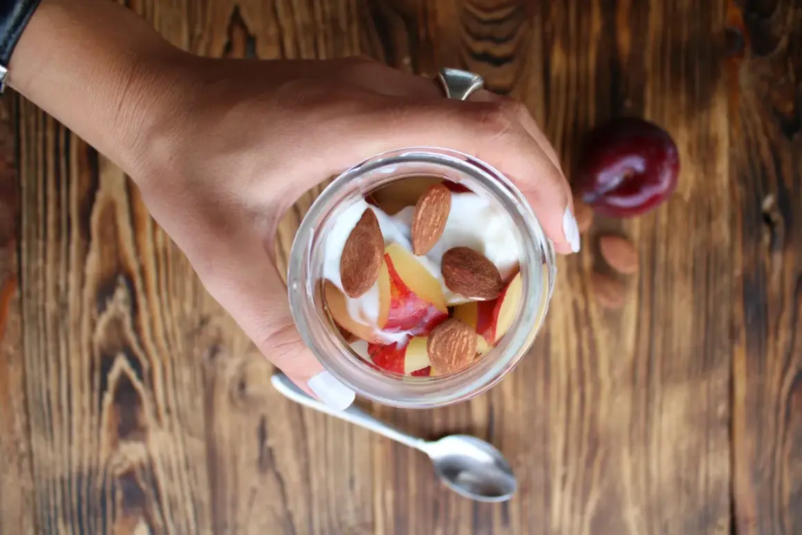 Un vasetto di yogurt con frutta e mandorle. Attenzione, le mandorle alzano la glicemia, ma sono deliziose!