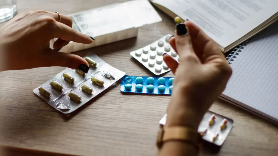 Mani con pillole e blister, cercando alternative cosa prendere al posto delle statine.