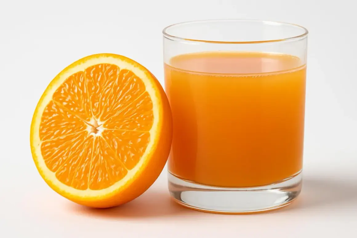 Mezza arancia succosa accanto a un bicchiere di succo d'arancia. Un'immagine che fa pensare alle arance e alla glicemia.