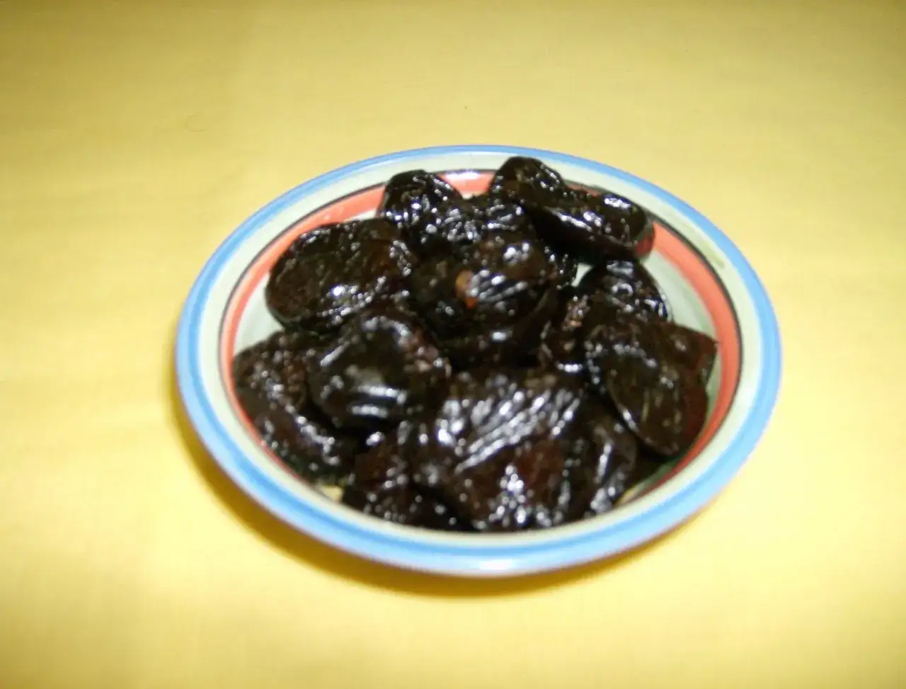 Prugne secche in una ciotola, un rimedio naturale per la stitichezza.