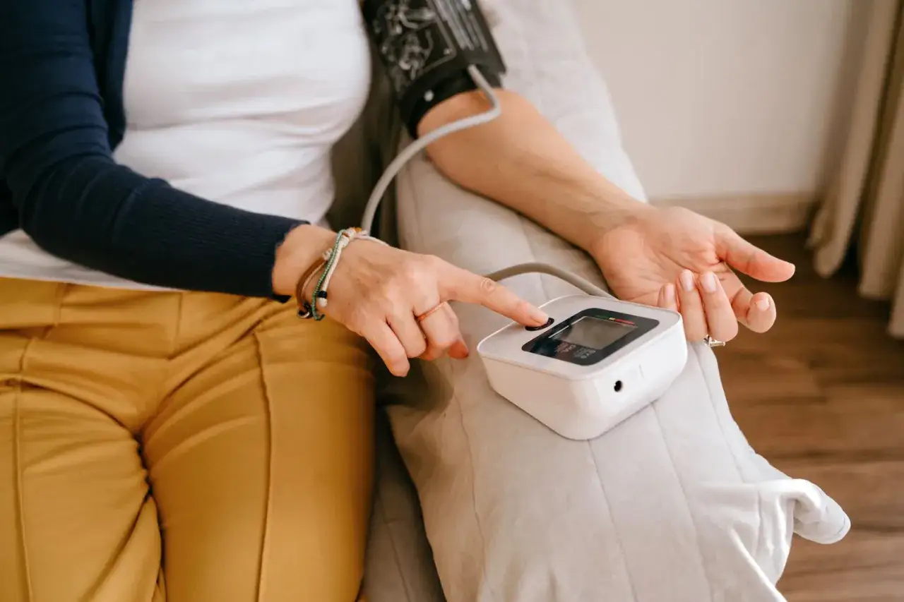 Donna controlla la pressione sanguigna, preoccupata per possibili picchi di pressione alta.