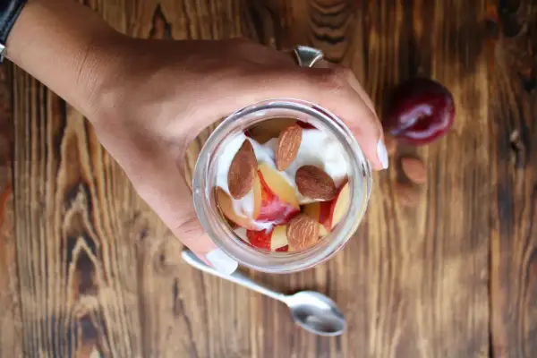 Un vasetto di yogurt con frutta e mandorle. Attenzione, le mandorle alzano la glicemia, ma sono deliziose!