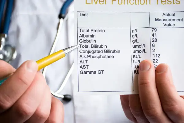 Medico indica esami del fegato, evidenziando i valori di bilirubina diretta e indiretta.